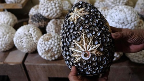 Perajin menata kap lampu berbahan limbah kerang di Desa Serangan, Denpasar, Bali, Selasa (14/11/2023). Penjualan produk kerajinan tersebut menembus pasar ekspor dengan menerima pesanan dari luar negeri yakni Maladewa, Jepang, Australia dan sejumlah negara-negara Eropa yang dijual seharga Rp10.000 hingga Rp500.000 per unit sesuai ukuran dan bentuk. ANTARA FOTO/Nyoman Hendra Wibowo/YU