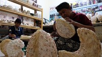 Perajin menyelesaikan pembuatan kap lampu berbahan limbah kerang di Desa Serangan, Denpasar, Bali, Selasa (14/11/2023). Kerajinan itu dijual dengan harga Rp 10 ribu hingga Rp 500 ribu per unit sesuai ukuran dan bentuk.