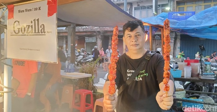 Pemilik Warung Raja Sambal, Ersad Sudiro, menunjukkan sate godzilla berukuran jumbo dengan panjang 55 cm dan berat 250 gram, Minggu (12/11/2023). (Foto: Ni Made Lastri Karsiani Putri/detikBali)