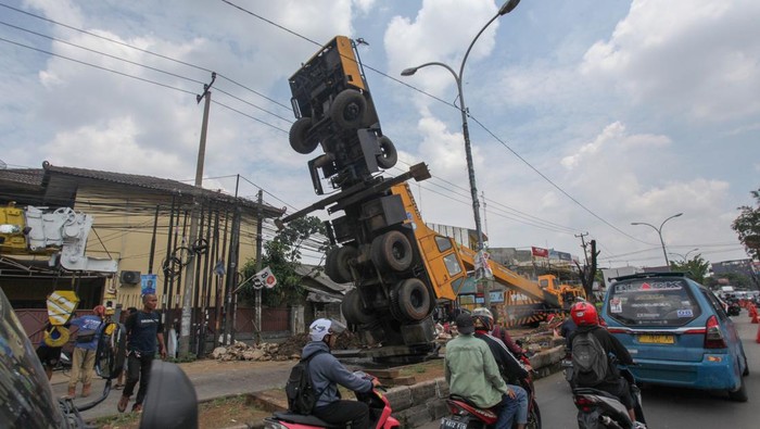 Penampakan Crane Roboh di Cibinong Sejumlah pengendara melintas di samping alat berat (crane) yang roboh di Jalan Raya Mayor Oking, Cibinong, Kabupaten Bogor, Jawa Barat, Rabu (15/11/2023). Alat berat tersebut roboh saat mengerjakan proyek perbaikan Jalan Raya Mayor Oking sehingga mengakibatkan sebagian lajur jalan tertutup, dan membuat kemacetan saat proses evakuasi. ANTARA FOTO/Yulius Satria Wijaya/nym.