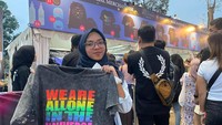 Salah seorang penonton memamerkan kaos Coldplay yang baru saja dibelinya. Foto: Tripa Ramadhan/detikcom