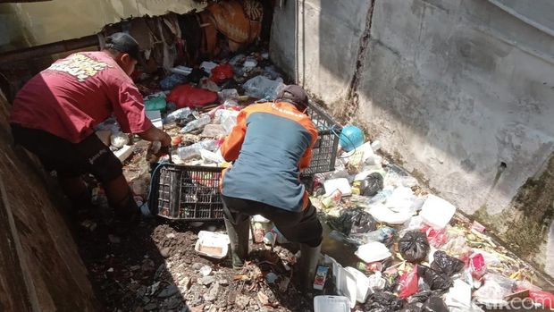 Petugas DCKPKP Gresik membersihkan sampah di saluran air