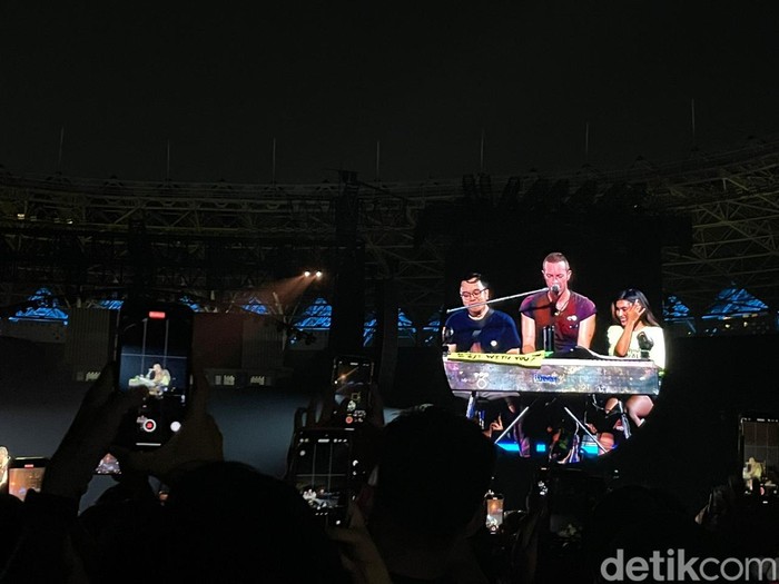 Momen dua penggemar yang beruntung bisa satu panggung dengan Coldplay: Rudi dan Airin. Permintaan lagu mereka pun dibawakan langsung oleh Chris Martin.