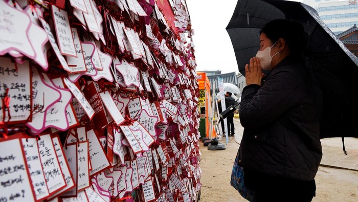 A mother lights a candle for her child's success in the annual College Scholastic Ability Test, at a Buddhist temple in Seoul, South Korea, November 16, 2023. REUTERS/Kim Soo-hyeon