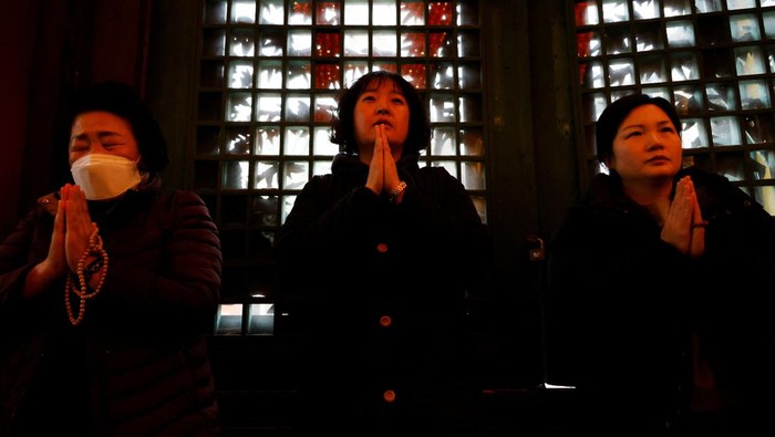 A mother lights a candle for her child's success in the annual College Scholastic Ability Test, at a Buddhist temple in Seoul, South Korea, November 16, 2023. REUTERS/Kim Soo-hyeon