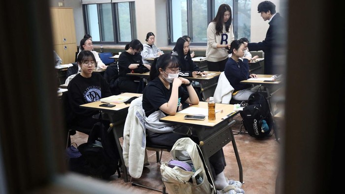A mother lights a candle for her childs success in the annual College Scholastic Ability Test, at a Buddhist temple in Seoul, South Korea, November 16, 2023. REUTERS/Kim Soo-hyeon