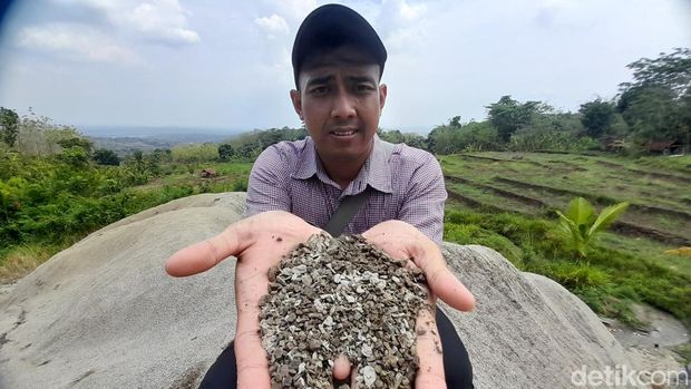 Kepala Dusun Tenjolaut Deni Hidayat sedang menunjukan tekstur pasir dari dekat di lokasi Gunungan Pasir di Blok Jukut, Desa Tenjolaut, Kecamatan Conggeang