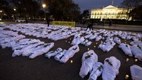 Spanduk besar bertuliskan Biden: Gencatan Senjata Sekarang bersama dengan kantong mayat palsu berwarna putih, melambangkan mereka yang tewas dalam konflik yang meningkat di Gaza dan Israel, dipajang di depan Gedung Putih, Washington, Rabu, 15 November 2023. Amnesty International mengadakan demonstrasi itu untuk secara visual mewakili ribuan warga Palestina yang tewas sejak perang Israel-Hamas dimulai.