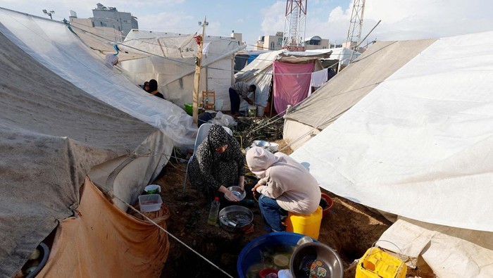 Potret Tenda Pengungsian Warga Gaza di Khan Younis Palestinians wash utensils at a tent camp sheltering displaced Palestinians, amid the ongoing conflict between Israel and Palestinian Islamist group Hamas, in Khan Younis in the southern Gaza Strip, November 14, 2023. REUTERS/Mohammed Salem TPX IMAGES OF THE DAY