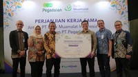Direktur Utama PT Bank Muamalat Indonesia Tbk Indra Falatehan (kanan) dan Direktur Utama PT Pegadaian Damar Latri Setiawan (kiri) memperlihatkan MoU Perjanjian Kerja Sama (PKS) pendaftaran porsi haji reguler di Muamalat Tower, Jakarta, Jumat (17/11).