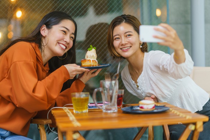 Ilustrasi perempuan dan sahabat makan di kafe