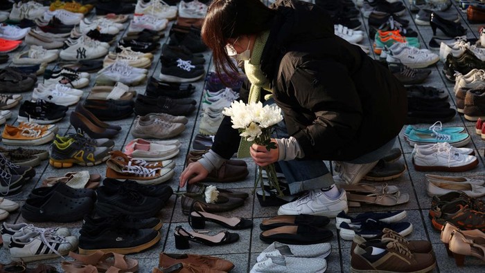 Instalasi Sepatu Simbol Duka Anak-anak Gaza An activist places a floral tribute on a pair of shoes symbolising Palestinians killed, amid the conflict between Israel and Palestinian Islamist group Hamas, during a rally in solidarity of Palestinians in Seoul, South Korea, November 17, 2023. REUTERS/Kim Hong-Ji