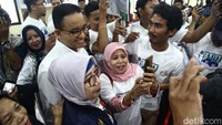 Emak-emak tampak berswa foto dengan Anies Baswedan. 