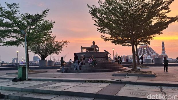 Patung ikon Suku Bugis, seorang wanita yang sedang menenun di Pantai Losari  dijadikan spot foto oleh wisatawan.