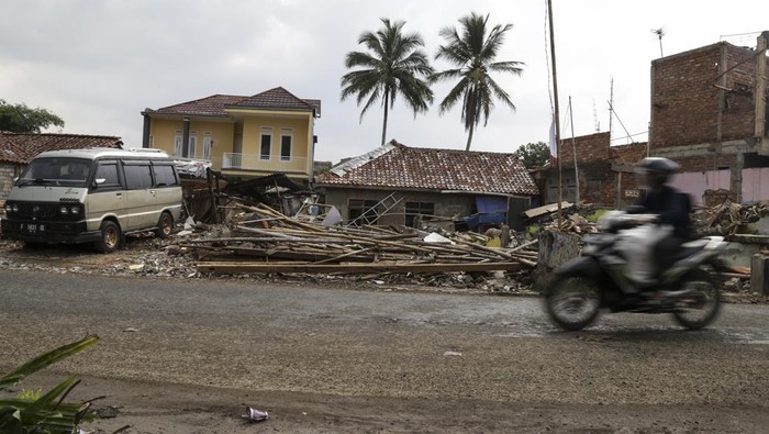 Pengendara motor melintas di depan bangunan yang terkena pembebasan lahan pembangunan Tol Bocimi seksi III di Selajambe, Cisaat, Kabupaten Sukabumi, Jawa Barat, Jumat (17/11/2023). Kementerian Pekerjaan Umum dan Perumahan Rakyat (PUPR) mencatat progres pembebasan lahan untuk pembangunan Tol Bocimi seksi 3 Cibadak-Sukabumi telah mencapai 86 persen dan pembangunannya ditargetkan selesai pada akhir 2024. ANTARA FOTO/Henry Purba/agr/nym.