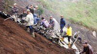 Warga sekitar terlihat berjaga di dekat bangakai Pesawat milik TNI AU Super Tucako yang terjatuh di kawasan Desa Keduwung,Kecamatan Puspo,Pasuruan.