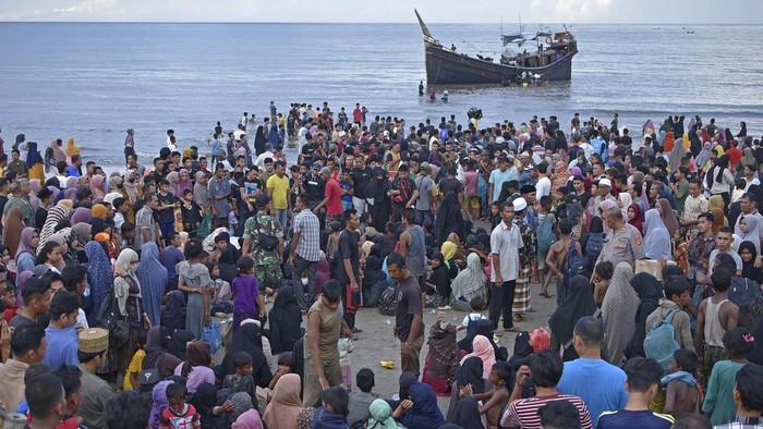 Potret Kedatangan Pengungsi Rohingya yang Ditolak Warga Aceh Ethnic Rohingya disembark from their boat upon landing in Ulee Madon, North Aceh, Indonesia, Thursday, Nov. 16, 2023. Some 240 Rohingya Muslims, including women and children, are afloat off the coast of Indonesia after two attempts to land were rejected by local residents. The boat left again a few hours later following the rejection. (AP Photo/Rahmat Mirza)