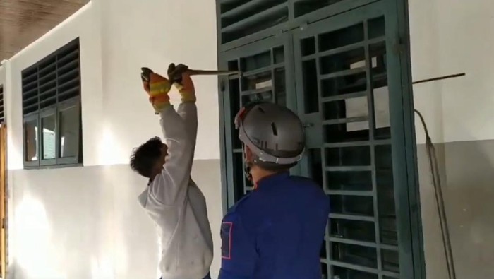 UIar sanca yang sebelumnya menggantung di pintu besi sekolah diamankan Damkar Tanjungbalai. (Istimewa)