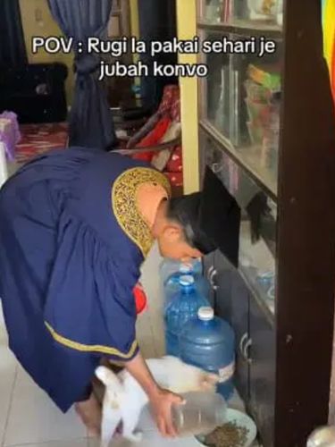 Aksi mahasiswa yang mengenakan topi dan jubah wisuda untuk kegiatan sehari-hari di rumah.