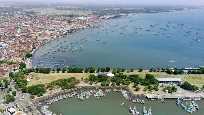Foto Udara Muncar, Pelabuhan Perikanan Tertua di Jawa Foto udara panorama Pelabuhan perikanan Muncar di Banyuwangi, Jawa Timur, Rabu (15/11/2023). Pelabuhan perikanan tertua yang ada sejak masa Kerajaan Blambangan tersebut menjadi penghasil ikan lemuru terbesar yang hingga saat ini masih eksis berkontribusi terhadap hasil perikanan di Indonesia. ANTARA FOTO/Budi Candra Setya/rwa.