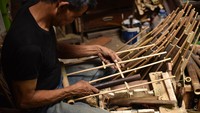 Proses pemasangan tabung nada ke rangka angklung.  