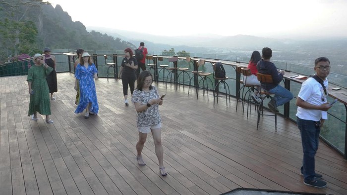 Pengunjung menikmati suasana senja sambil menunggu matahari tenggelam di Enam Langit kawasan pegunungan Menoreh, Candirejo, Borobudur, Magelang, Jateng Sabtu (18/11/2023). Enam Langit merupakan destinasi wisata alternatif di kawasan Borobudur yang menyuguhkan keindahan pemandangan alam dari atas bukit yang dilengkapi dengan aneka kuliner tradisional. ANTARA FOTO/Anis Efizudin/nz