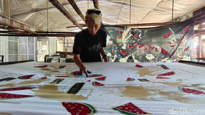Perajin menggambar batik motif ngerinya perang Palestina di atas kain. Batik motif Palestina ini dibuat perajin Kulon Progo. Foto diambil Sabtu (18/11/2023).