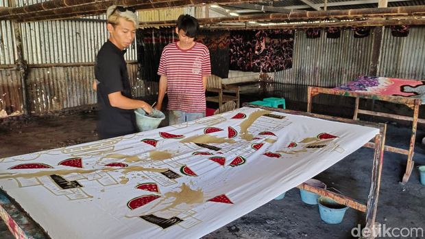 Perajin menggambar batik motif ngerinya perang Palestina di atas kain. Batik motif Palestina ini dibuat perajin Kulon Progo. Foto diambil Sabtu (18/11/2023).