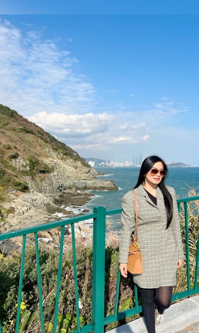 Menikmati keindahan Korea Selatan, Titi tak lupa berpose dengan latar belakang pemandangan laut di sana. Lagi-lagi penampilannya terlihat tetap stylish dan sopan dengan memadukan blazer panjang kotak-kotak warna abu-abu, celana legging dan dalaman hitam. Foto: Instagram/@titi_kamall