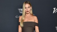 Margot Robbie malam itu tampil dengan gaun bernuansa gelap yang membuat warna pirang rambutnya semakin mencolok. (Foto: AFP/LISA OCONNOR)