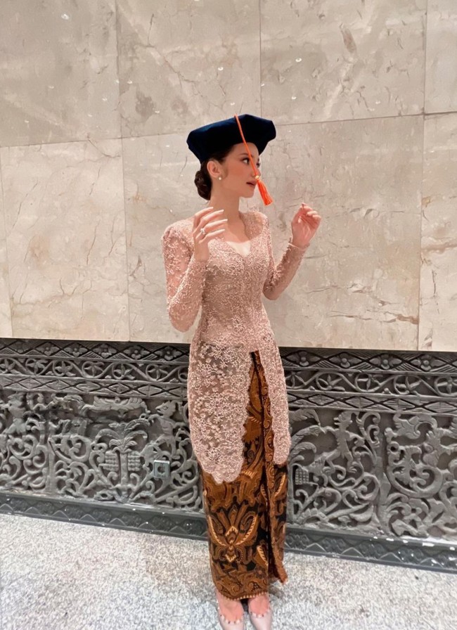 Penampilan Enzy saat wisuda pun tak kalah mencuri atensi. Mengenakan kebaya berwarna nude dipadukan dengan heels berwarna senada, penampilan Enzy terlihat cantik dan anggun. Foto: Instagram/@enzystoria