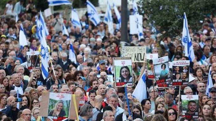 Family members, friends and supporters of hostages held in the Gaza Strip since the October 7 attack by Hamas militants in southern Israel, wave flags and hold images of those taken during a protest calling for their release outside the Prime Ministers office in Jerusalem on November 18, 2023, amid the ongoing battles between Israel and the Palestinian group Hamas. (Photo by GIL COHEN-MAGEN / AFP)