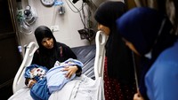 Wanita Palestina Iman menggendong bayi kembarnya yang baru lahir Uday dan Hamza Abu Odah.