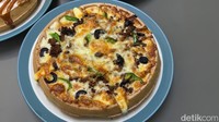 Pizza waffle Rp 75.000 ini dilengkapi dengan keju meleleh, potongan paprika, potongan buah zaitun, dan beberapa cincangan daging. Rasanya pun ternyata sangat cocok!Foto: Detikcom / Atiqa Rana