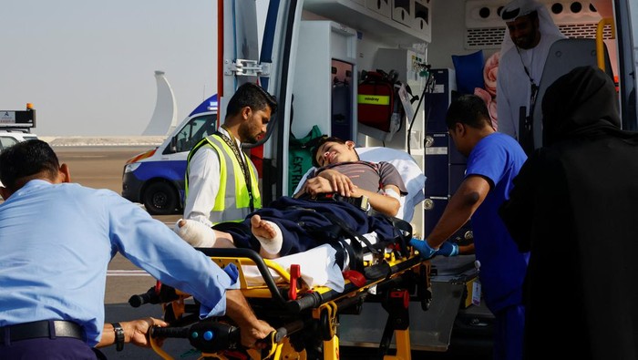 An injured child is assisted as Palestinian children and families who were evacuated from Gaza, amid the ongoing conflict between Israel and the Palestinian Islamist group Hamas, arrive to receive treatment in Abu Dhabi, United Arab Emirates, November 18, 2023. REUTERS/Rula Rouhana