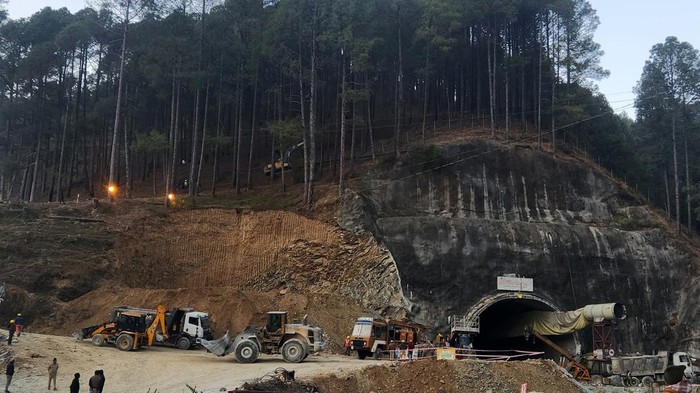 Seminggu Terowongan Ambruk di India, Puluhan Pekerja Masih Terjebak Rescuers use a digger to make a path at the top of the mountain as part of an alternate plan to reach the workers trapped in a tunnel after a portion of it collapsed, in Uttarkashi in the northern state of Uttarakhand, India, November 18, 2023. REUTERS/Saurabh Sharma NO RESALES. NO ARCHIVES