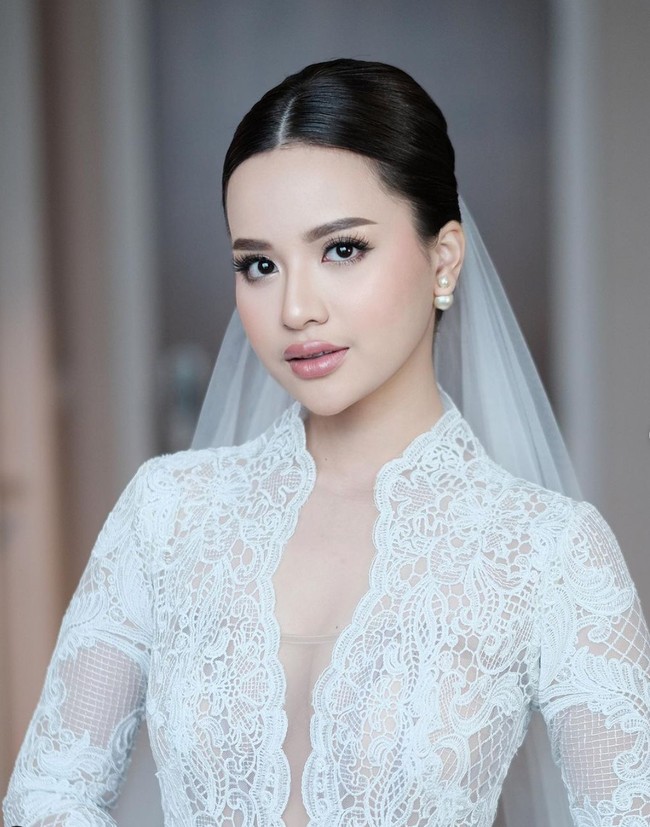 Penampilan Anggi juga terlihat sederhana dengan rambut yang ditata rapi ke belakang dan mengenakan veil. Ia juga tak mengenakan aksesori berlebihan, hanya sepasang anting tusuk di telinganya. Foto: Instagram/@anggimarito