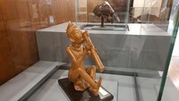 Masih bersentuhan musik, Pemerintah RI juga menyumbang patung A Balinese tune. Karya seni ini memperlihatkan seorang laki-laki beratribut tradisi di kepala sedang bersilang kaki bermain suling. Foto: Dok Kemendikbudristek