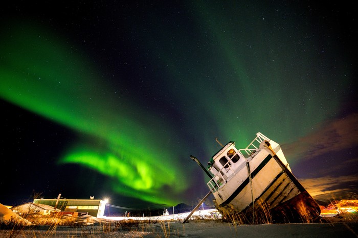 Northern Lights, also called Aurora Borealis, illuminate the night sky over a boat on the shore in Sommaroy, Norway November 19, 2023. REUTERS/Lisi Niesner     TPX IMAGES OF THE DAY
