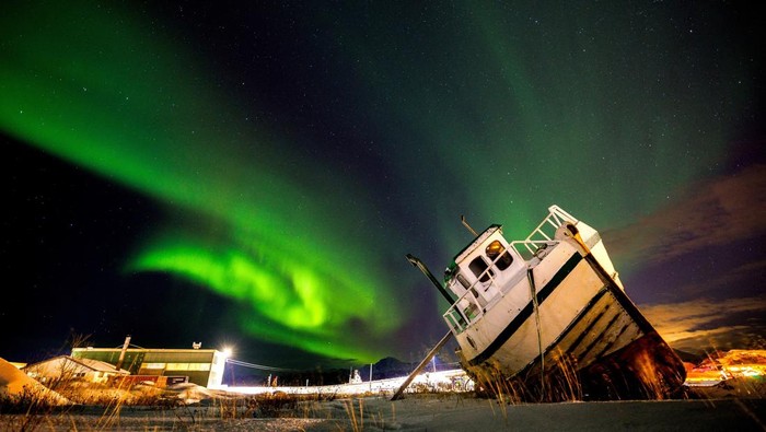 Keindahan Aurora Borealis Terangi Langit Malam di Norwegia Northern Lights, also called Aurora Borealis, illuminate the night sky over a boat on the shore in Sommaroy, Norway November 19, 2023. REUTERS/Lisi Niesner TPX IMAGES OF THE DAY