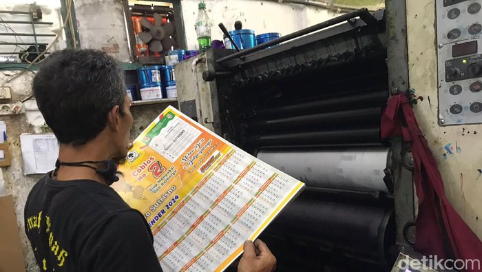 Salah seorang karyawan percetakan Al Fath sedang mencetak kalender orderan dari Caleg, Senin (20/11).