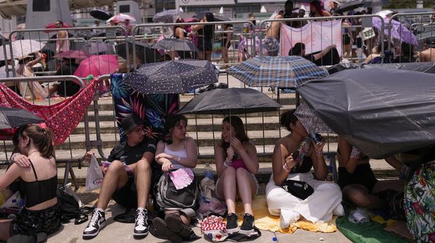 Taylor Swift fans wait for the doors of Nilton Santos Olympic stadium to open for her Eras Tour concert amid a heat wave in Rio de Janeiro, Brazil, Saturday, Nov. 18, 2023. A 23-year-old Taylor Swift fan died at the singer's Eras Tour concert in Rio de Janeiro Friday night, according to a statement from the show's organizers in Brazil.  (AP Photo/Silvia Izquierdo)