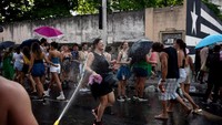 Cuaca panas ekstrem pun membuat beberapa fans memilih untuk menyirami air ke pada para penonton lain. AFP/TERCIO TEIXEIRA