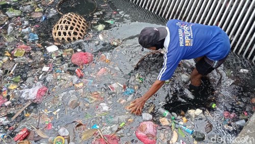 Petugas mengangkut sampah dari sungai di Denpasar, Bali.