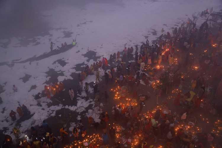 Potret Warga India Gelar Ritual di Sungai Penuh Limbah Beracun Hindu devotees worship the Sun god as they stand amidst the foam covering the polluted Yamuna river during the Hindu religious festival of Chhath Puja on a smoggy morning in New Delhi, India, November 20, 2023. REUTERS/Anushree Fadnavis TPX IMAGES OF THE DAY