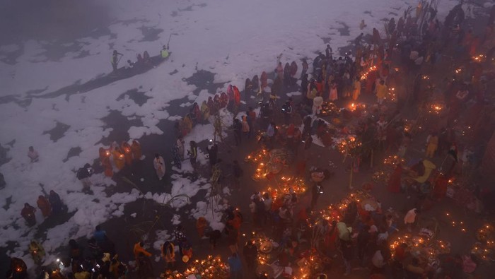 Potret Warga India Gelar Ritual di Sungai Penuh Limbah Beracun Hindu devotees worship the Sun god as they stand amidst the foam covering the polluted Yamuna river during the Hindu religious festival of Chhath Puja on a smoggy morning in New Delhi, India, November 20, 2023. REUTERS/Anushree Fadnavis TPX IMAGES OF THE DAY