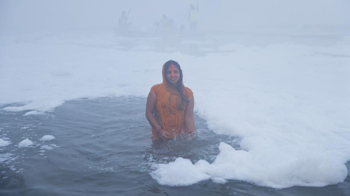 Potret Warga India Gelar Ritual di Sungai Penuh Limbah Beracun Hindu devotees worship the Sun god as they stand amidst the foam covering the polluted Yamuna river during the Hindu religious festival of Chhath Puja on a smoggy morning in New Delhi, India, November 20, 2023. REUTERS/Anushree Fadnavis TPX IMAGES OF THE DAY