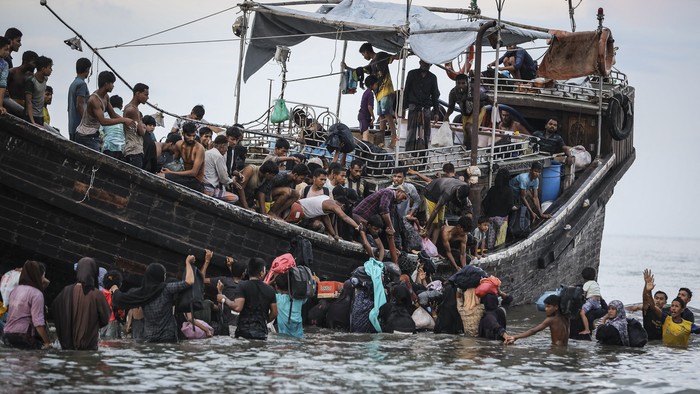 Newly arrived Rohingya refugees return to a boat after the local community decided to temporarily allow them to land for water and food in Ulee Madon, Aceh province, Indonesia, on November 16, 2023. About 250 Rohingya refugees reached western Indonesia on a overcrowded wooden boat on November 16, 2023, bringing the total number of refugees reported by local officials to have arrived this week to nearly 600. (Photo by amanda jufrian / AFP)