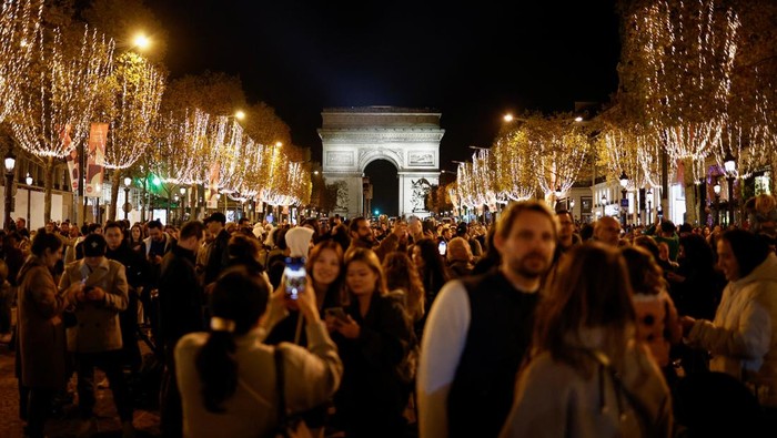 Ribuan Orang Meriahkan Pembukaan Lampu Natal di Sepanjang Jalan Paris People watch the unveiling of the annual Christmas holiday lights along the Champs-Elysees, with the Arc de Triomphe in the background, in Paris, France, November 19, 2023. REUTERS/Benoit Tessier