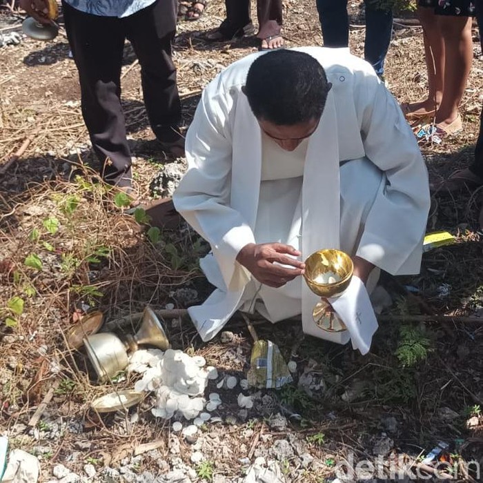 Tangkapan layar seorang pater memungut piala berisi hostia yang tercecer di pinggir jalan.